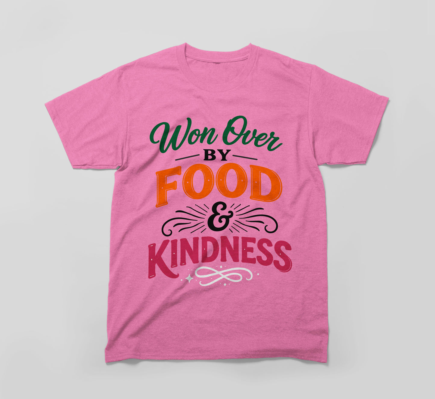 pink t-shirt with 'won over by food & kindness' colorful graphic text design