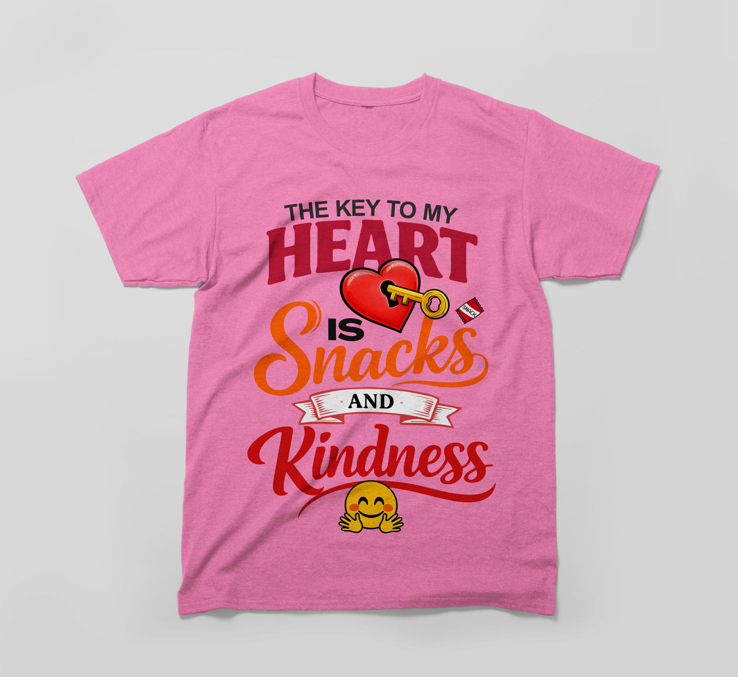 pink t-shirt with 'the key to my heart is snacks and kindness' text, heart, key, and smiley emoji design
