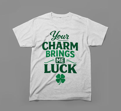 White t-shirt with green text 'Your charm brings me luck' and a four-leaf clover graphic