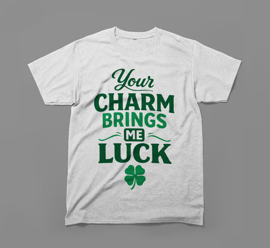 White t-shirt with green text 'Your charm brings me luck' and a four-leaf clover graphic